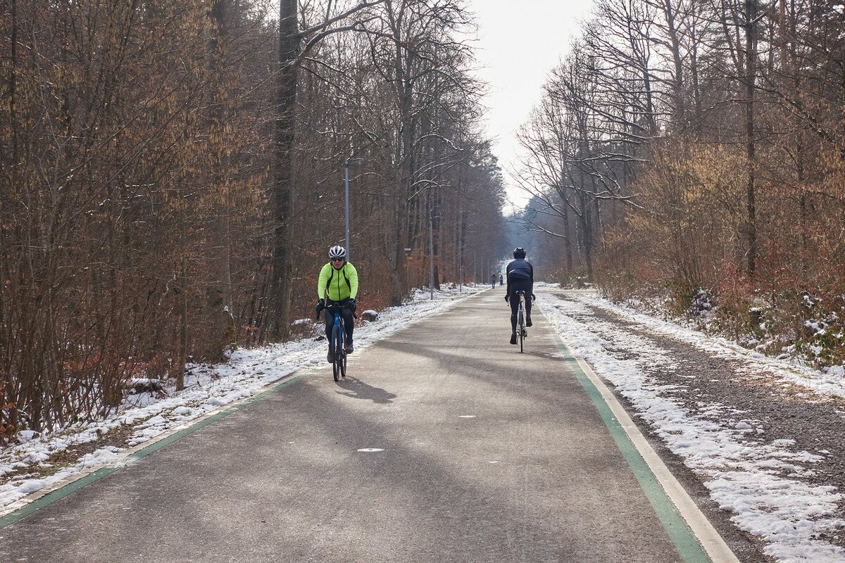 Das Bild zeigt den Radschnellweg Stuttgart–Böblingen. Die etwa vier Meter breite Fahrbahn ist geräumt und gestreut, im Vordergrund sind zwei Radfahrer. 