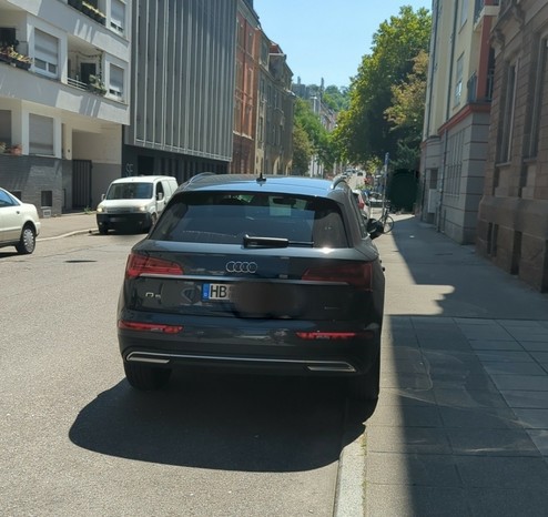 ein SUV parkt teilweise auf dem Gehweg.