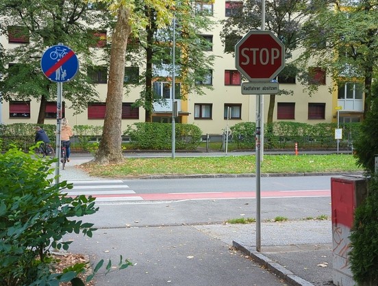 "Radfahrer absitzen" an einem Stop-Schild.