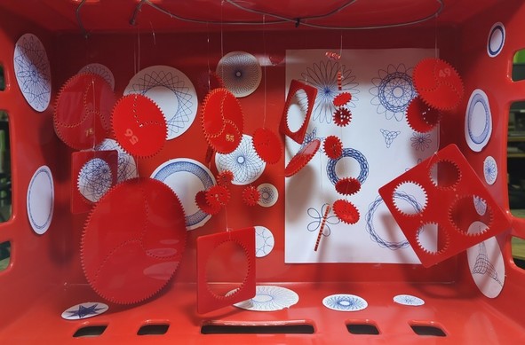 eine Sammlung von gelochten "Innen- & Außen-" Zahnrädern für Spirographen, dazu noch die gezeichneten Ergebnisse