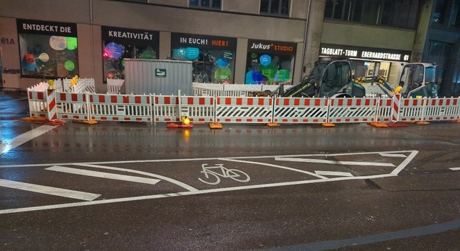 ein Fahrrad Piktogramm mitten auf der Straße, in einer Sperrfläche zwischen zwei durchgezogenen Linien