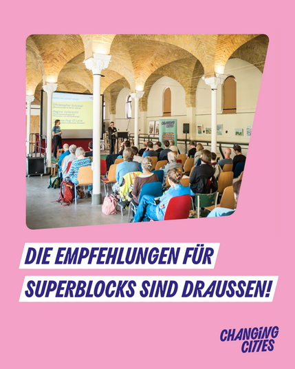 Die Empfehlungen für Superblocks sind draußen! Foto der Veranstaltung auf Rosa Hintergrund: Menschen auf Stühlen von hinten, auf der Bühne stehen 2 Personen vor einer Präsentation.
